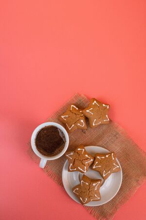 White coffee Cup and saucer on pink background with gingerbread. Copy space textの写真素材
