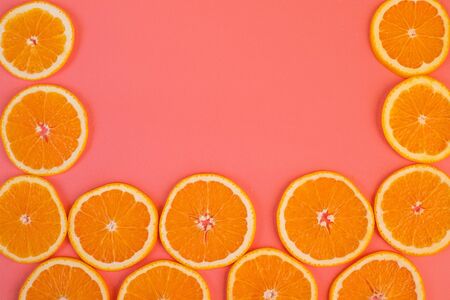 Background of ripe oranges cut on pink background. Conceptual creative approachの写真素材
