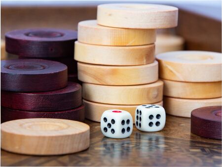 Backgammon. White cubes and chips on a blackboard.の写真素材