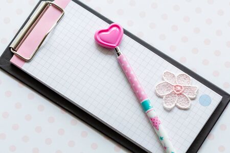 Notepad and pink pen with a heart. Space for romantic wishes text, sign. Valentine's Day, March 8th.