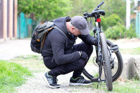 Russia. Krasnodar on April 24, 2020. Bicycle repair. A cyclist corrects an accident on a bicycle. Bike breakdown.のeditorial素材