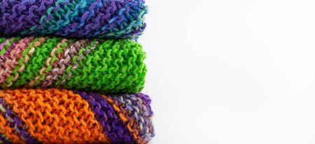 A stack of handmade knitwear. The texture of the knitted fabric. Knitting. Bright multi-colored...