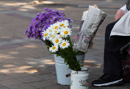 Grandma sells flowers in the streets. Street trading.の写真素材