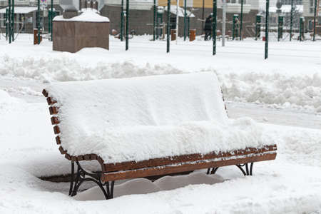 Snow-covered bench after a snowfall in Krasnodar in the courtyard of a residential building.の写真素材