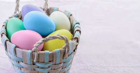 Multi-colored Easter eggs in a wicker basket. Easter eggs in pastel colors.の写真素材