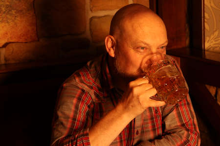 Man quietly drinks a bear in a pub