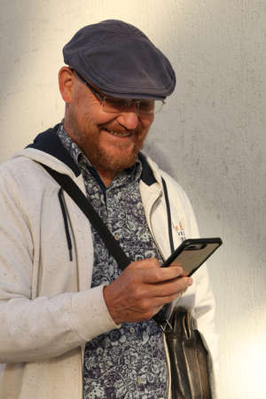 Person on the street smiling at his phone