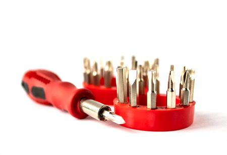 Screwdriver with a red handle and a set of bits on a white background.
