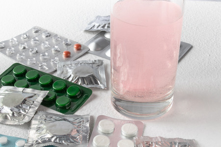 Soluble tablet in a glass of water. Tablets in packing on a light background. Pills. pills in packs.の写真素材