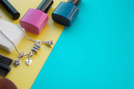 Cosmetic accessories. Brush for blush, brush, varnish on a yellow, green background. With empty space on the right. View from aboveの写真素材