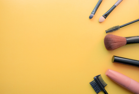 Makeup brushes, brushes for everyday makeup. Cosmetic items on yellow background, closeup. With empty space from the left.の写真素材