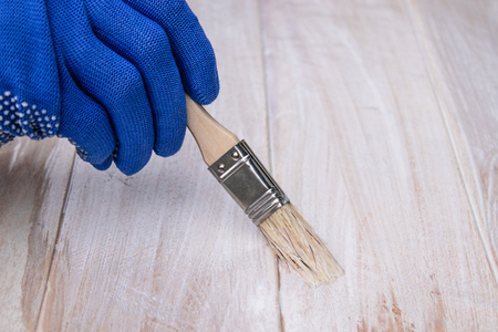 Man paints a white paint surface. Coloring boards. Painting wooden boards.の写真素材