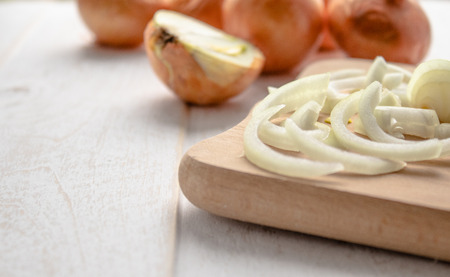 Sliced fresh onions on wooden background. Vegetables for a healthy diet. Vegan food. Yellow onionの写真素材