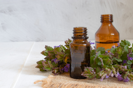Essential aromatic oil with flowers on wooden background. Selective focus. Natural essential oil.の写真素材