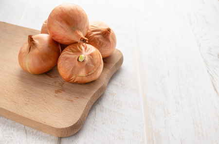Fresh onion on wooden background. Ripe onions (Allium cepa) or onions or vegetarian and vegan food. Vegetables for a healthy diet.の写真素材