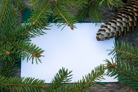 Green branches of a Christmas tree and cones on the background of old, wooden boards. Top view with copy space for your text.の写真素材