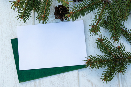 Green branches of a Christmas tree and cones on a white board background. Top view with copy space for your text.の写真素材