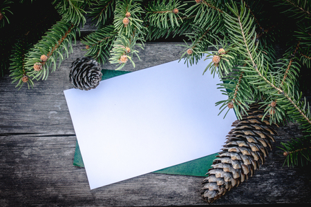 Green branches of a Christmas tree and cones on the background of old, wooden boards. Top view with copy space for your text.の写真素材