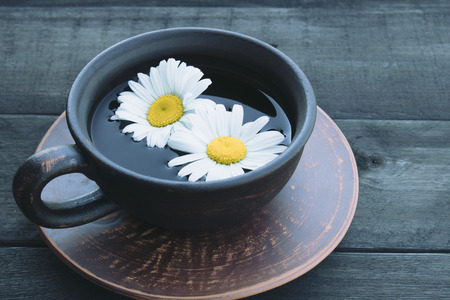 cup of tea with chamomile on an old wooden table. top view with copy space. Close-up.の写真素材