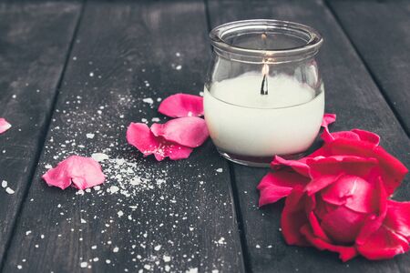Rose and burning candle on an old wooden board. Flower frame. Pattern texture for design.の写真素材