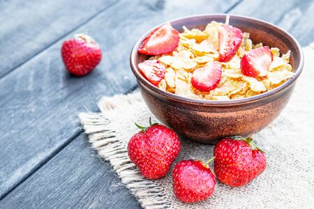 Fresh homemade muesli, muesli with strawberries in a plate on a dark gray background, selective focus, copy spaceの写真素材