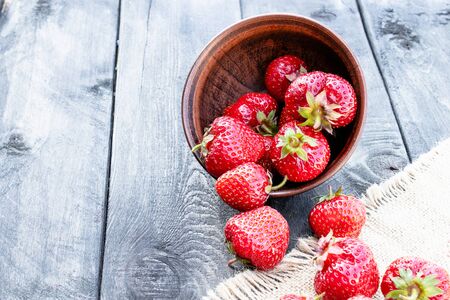 ripe red strawberries scattered on a table on burlap. close-upの写真素材