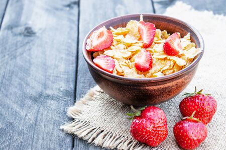 Fresh homemade muesli, muesli with strawberries in a plate on a dark gray background, selective focus, copy spaceの写真素材