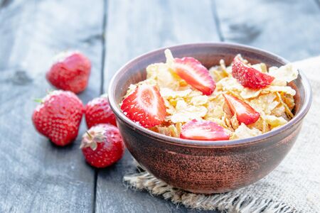 Fresh homemade muesli, muesli with strawberries in a plate on a dark gray background, selective focus, copy spaceの写真素材