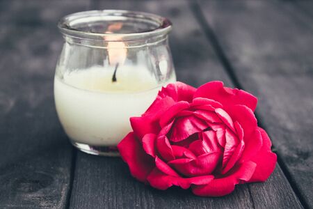Rose and burning candle on an old wooden board. Flower frame. Pattern texture for design.の写真素材