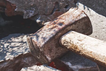 Rusty sledgehammer on broken bricks and concrete stones. Metal sledgehammer.の写真素材