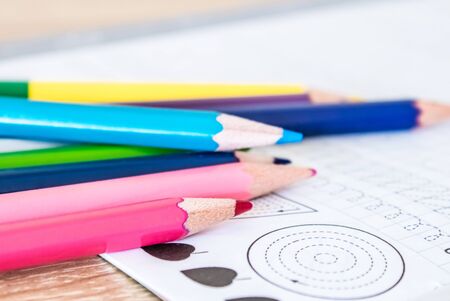 Colored pencils scattered on a school notebook. Close-up.の写真素材