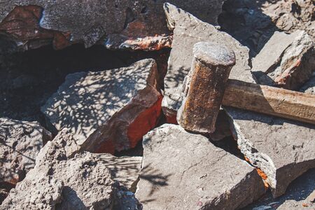 Rusty sledgehammer on broken bricks and concrete stones. Metal sledgehammer.の写真素材