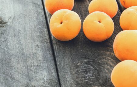 Ripe yellow apricots lie on a wooden table. Close-up.の写真素材