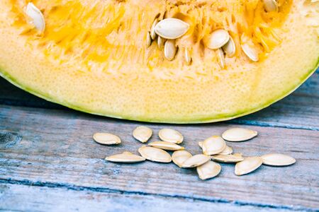 Closeup of a pumpkin with seeds on dark blue old boards. Autumn harvest.の写真素材