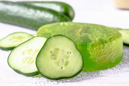 Sliced cucumber and soap on a white background. Home body care cucumber and care concept. Treatments with cucumber soap.の写真素材