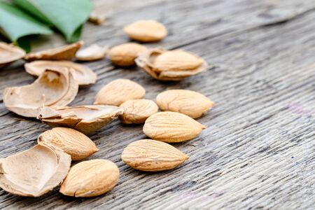 The core of apricots and stones on the background of old boards. Apricot pits for the manufacture of...