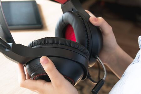 Black headphones in the hands of a child. Close-up.の写真素材