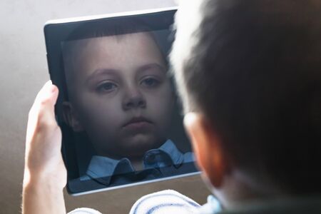 The child is learning distance learning lessons on a tablet. Home schooling, Social distance, The concept of distance learning and online learning.の写真素材