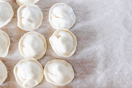 Raw dumplings with minced meat on the table. The process of making homemade dumplings. Russian national food.の写真素材