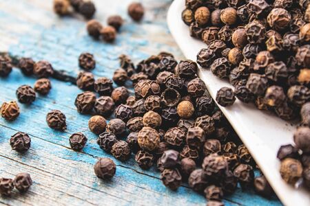 The black pepper is scattered on blue boards. Black pepper spices and seasonings for cooking.の写真素材