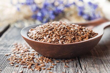 Flax seeds in a spoon on a wooden table. Flaxseed is used to prevent heart disease and being overweight.の写真素材