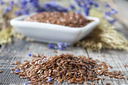 Flax seeds or flaxseed are on old boards. Flaxseed is used to prevent heart disease and being overweight.の写真素材
