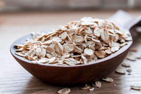 Gray oatmeal in a larger spoon on the table. The concept of a healthy diet, breakfast.の写真素材