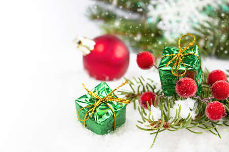 Christmas card with a green branch of a Christmas tree and red round toys on a white background. Composition of Christmas holidays.の写真素材
