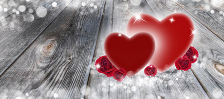 Two hearts and roses on a wooden background and white bokeh for Valentine's Day. Romantic and abstract background.の写真素材