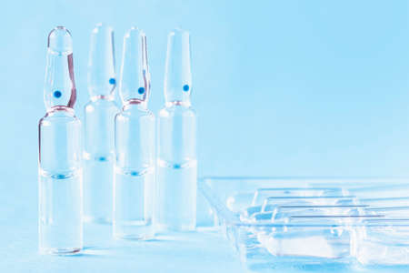 Medical ampoules on the table near the ampoule packaging. Medical glass ampoules close-up.の写真素材