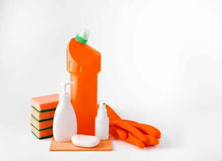 Plastic bottles for washing dishes, glass and tiles, detergents for microwave ovens and stoves, gloves and sponges on a white background. The concept of washing and cleaning.の写真素材