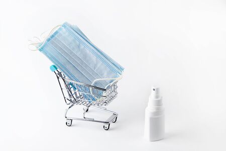 medical masks for face and spray for disinfection in a shopping basket.の写真素材