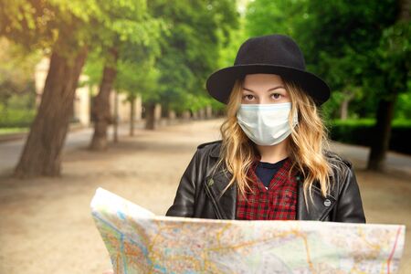 Young girl with a city map on the street on a trip. Looking at the cameraの写真素材
