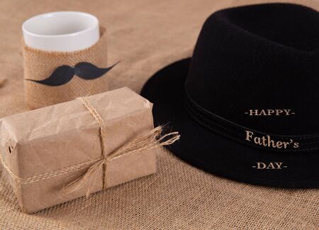 gift box on the table. Next to a cup with a glued mustache.の写真素材